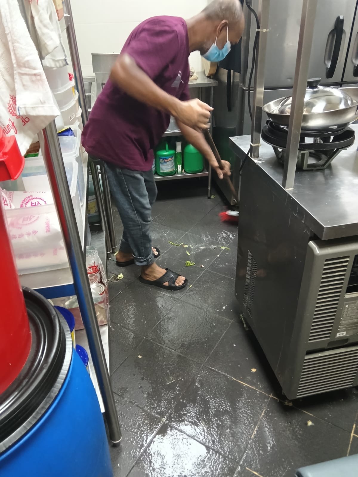 Sani Clean crew member wiping a stainless steel counter