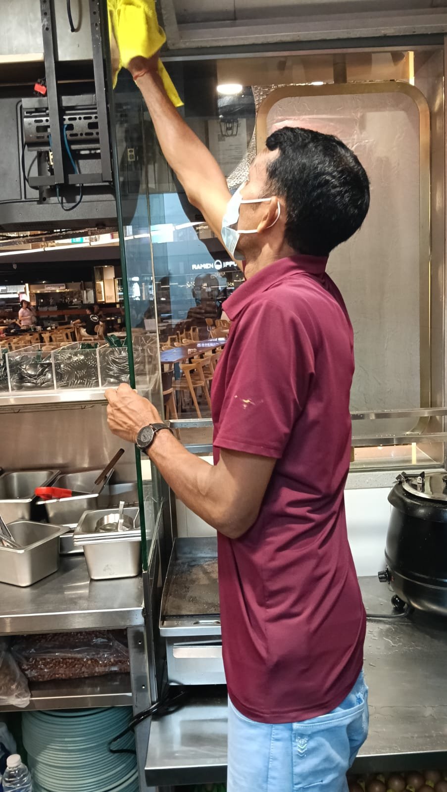 Sani Clean crew member cleaning a stainless counter edge