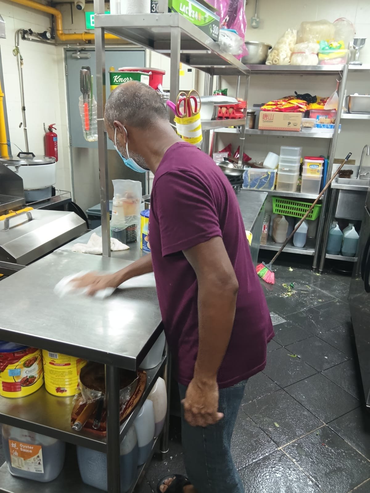 Sani Clean crew member sweeping a kitchen floor