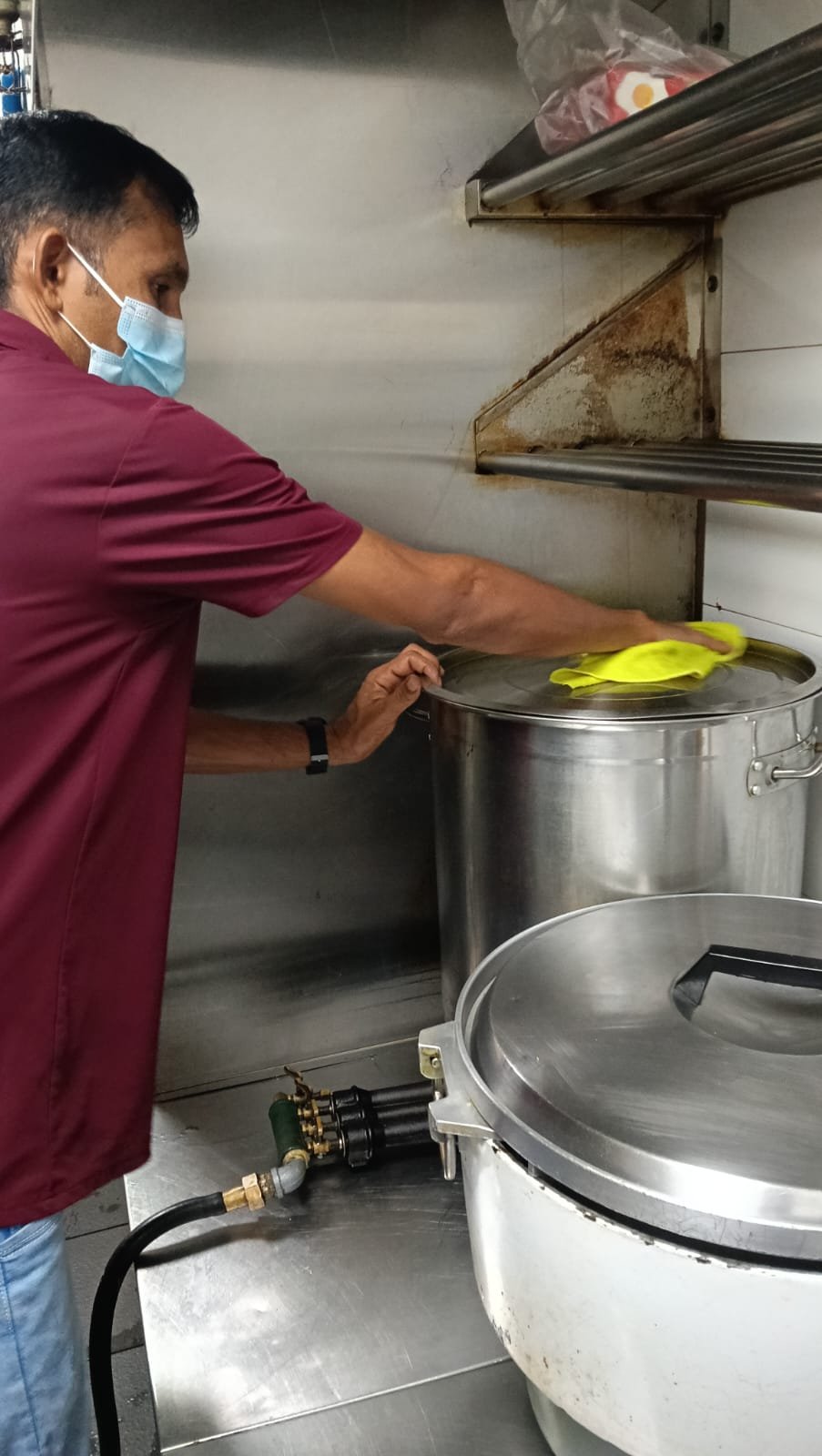 Sani Clean staff wiping down a commercial refrigerator
