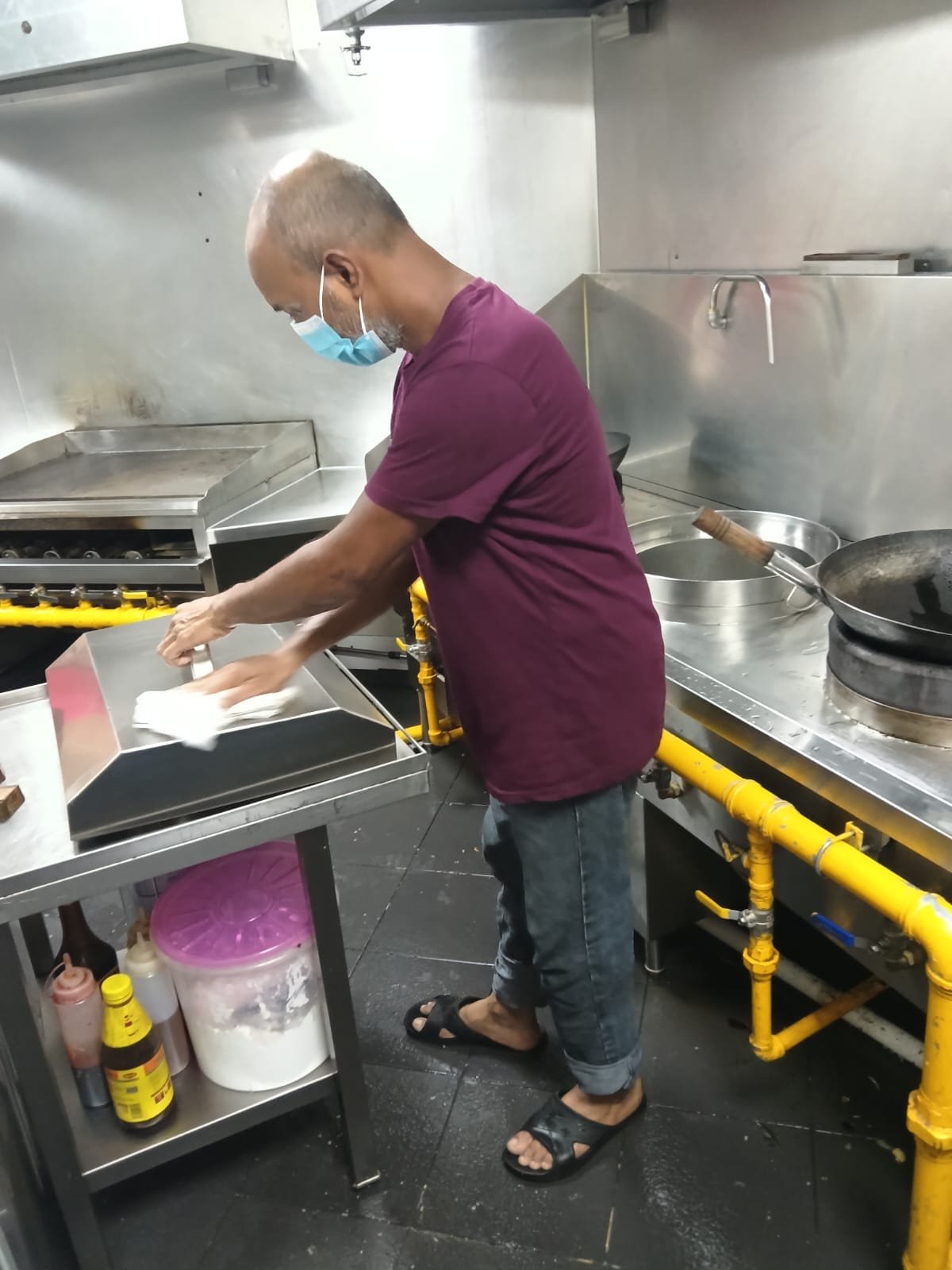 Sani Clean staff cleaning a wok station and exhaust hood
