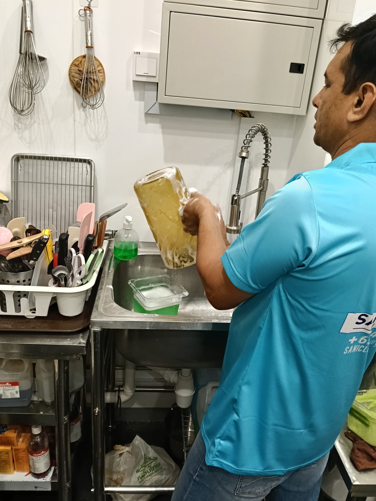 Sani Clean crew member cleaning equipment at a counter