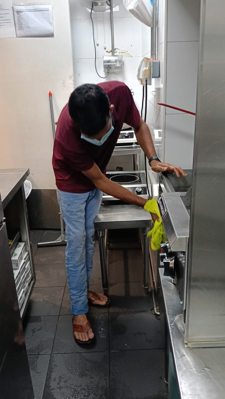 Sani Clean crew member cleaning overhead glass partitions